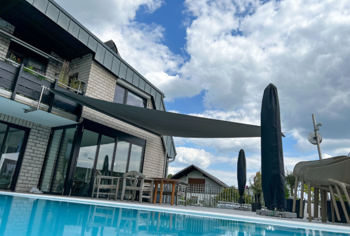 Stilvolles modernes Haus mit Pool und Patio, ergänzt durch ein GFS Sonnensegel für zusätzlichen Komfort im Freien.