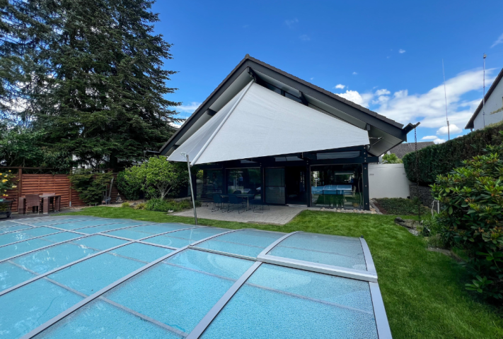 Haus im Hinterhof mit grauem Sonnensegel und Pool. GFS Sonnensegel Terrasse individuelle Anfertigung.