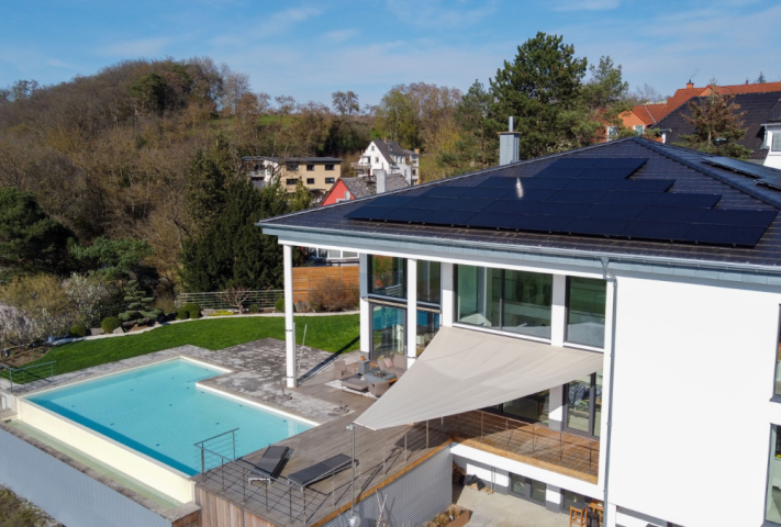 Terrasse mit Pool ausgestattet, mit einem Sonnensegel für Schatten und Schutz.