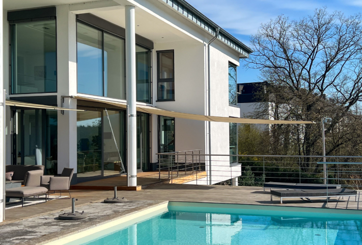 Stilvolles modernes Haus mit Pool und Patio, ergänzt durch ein GFS Sonnensegel für zusätzlichen Komfort im Freien.