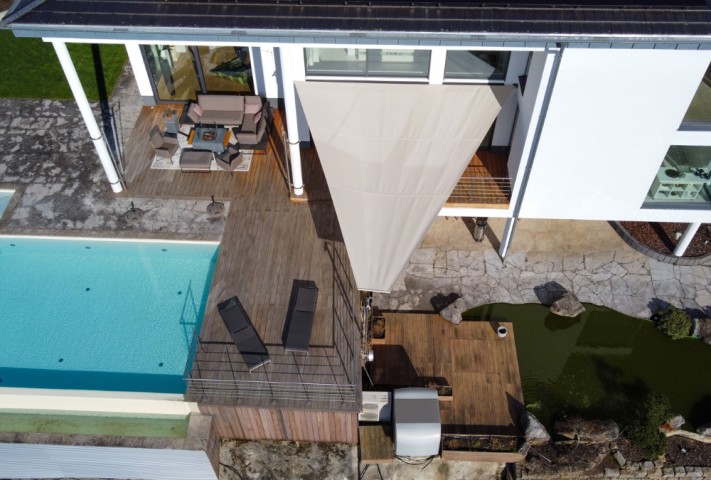 Terrasse mit Pool von oben ausgestattet, mit einem Sonnensegel für Schatten und Schutz.